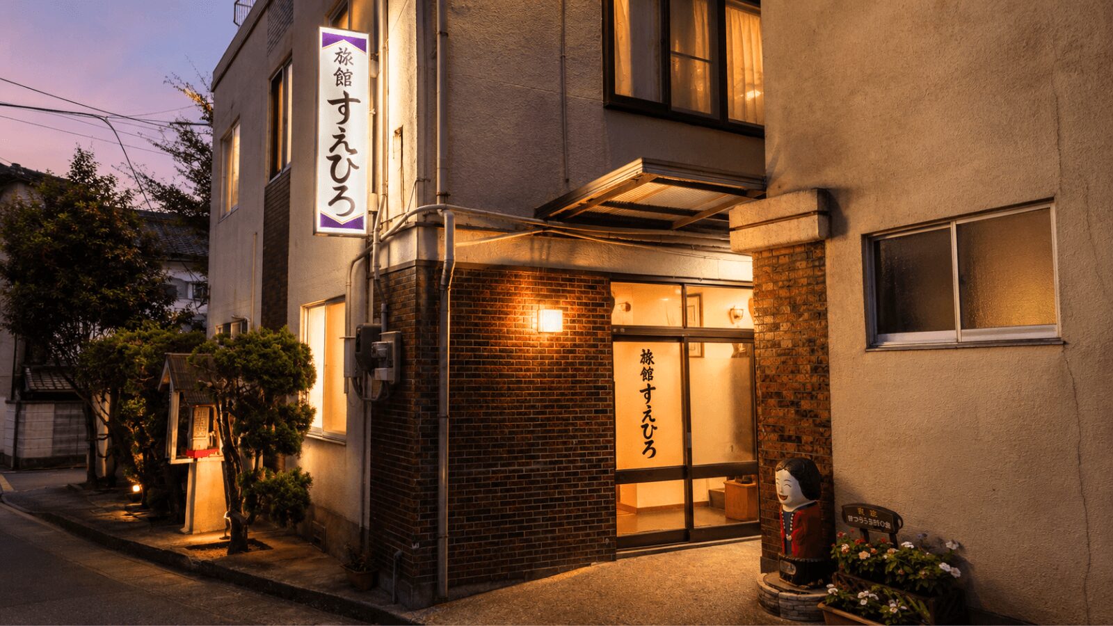夕方の明かりが灯る松浦市すえひろ旅館の外観